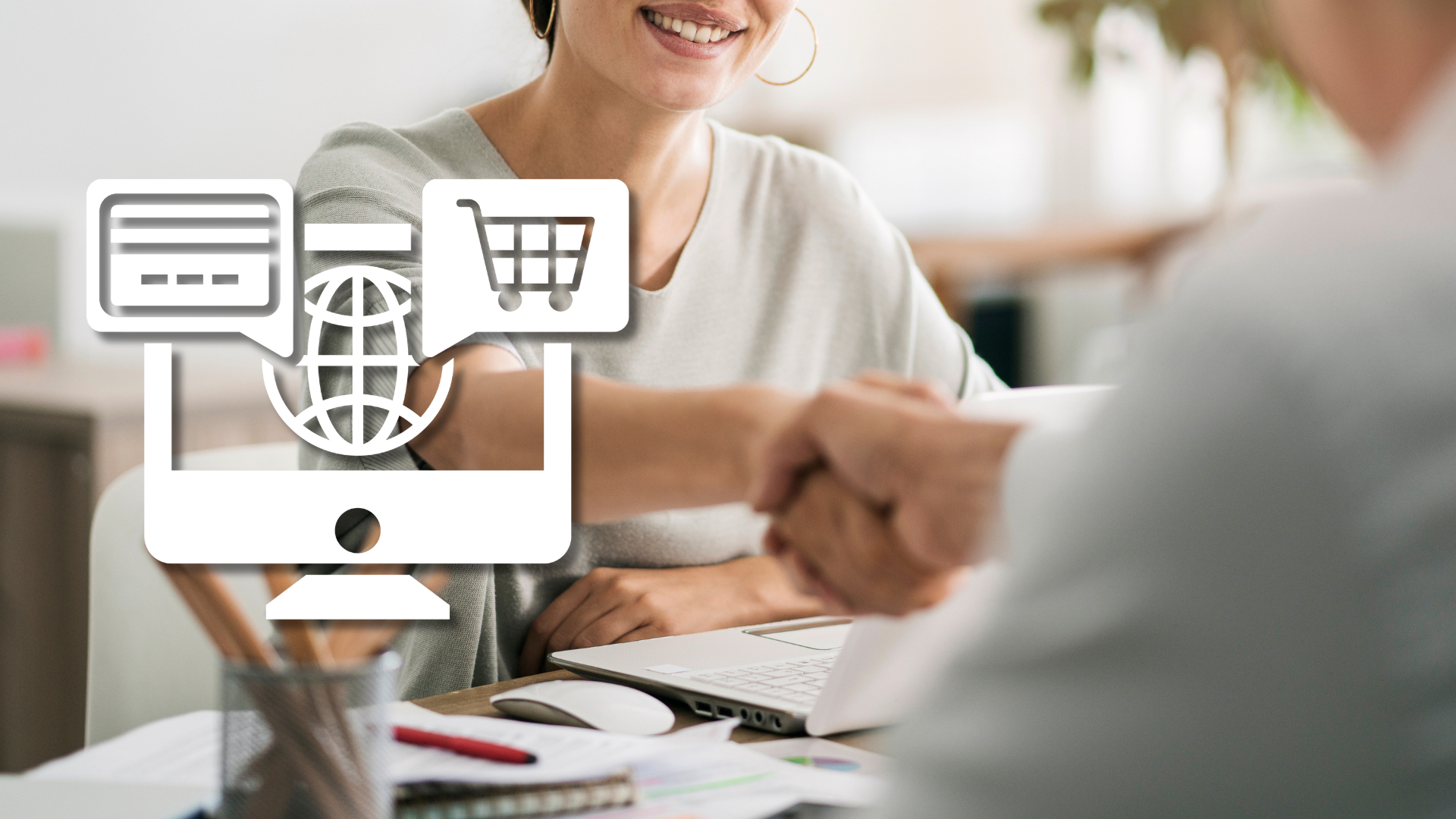 Händedruck am Schreibtisch mit Laptop, daneben ein weißes Onlineshop-Icon – Festanstellung eines E-Commerce-Spezialisten