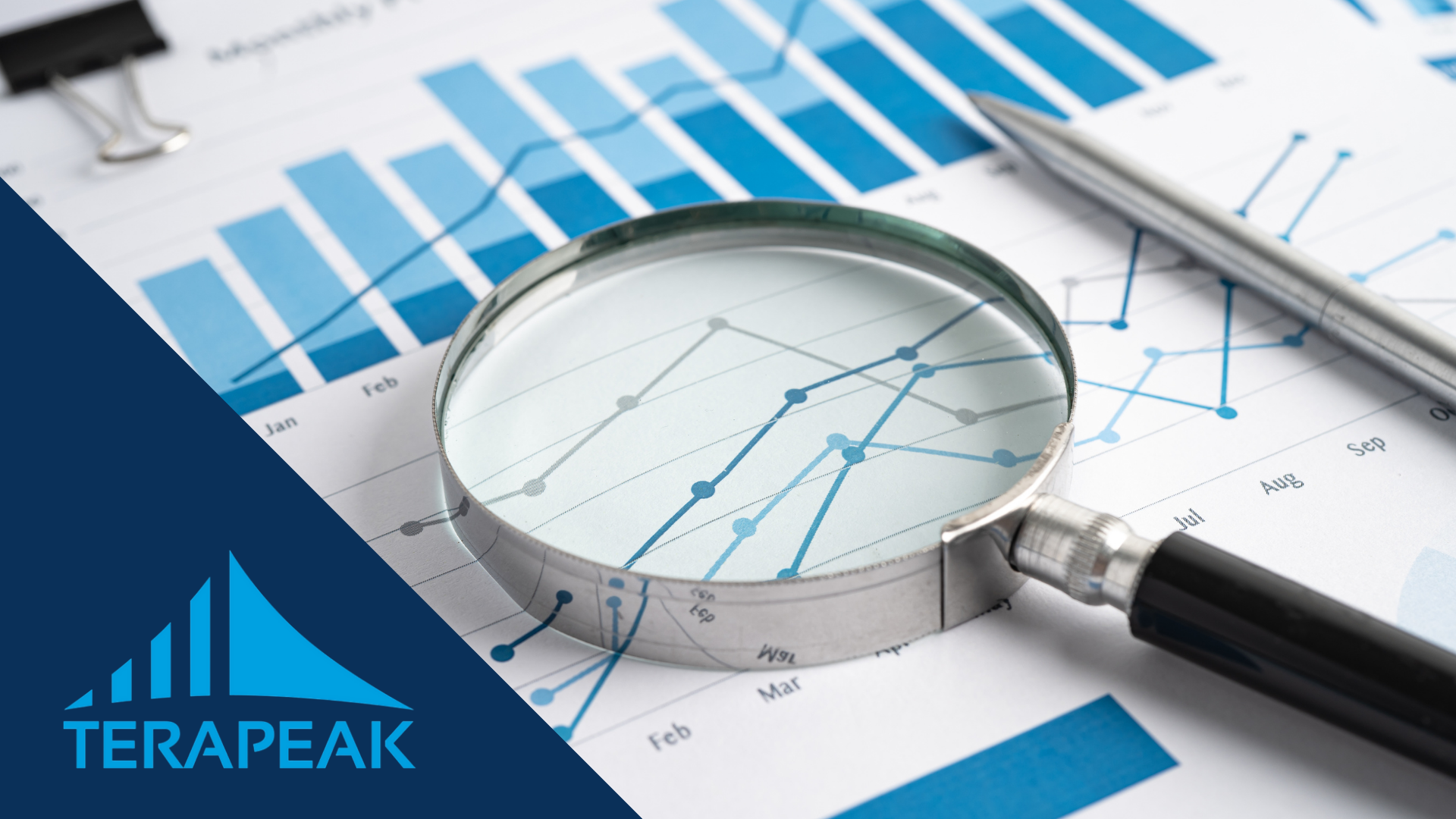 Lupe und Stift auf ausgedruckten Verkaufsdiagrammen mit dem Logo von Terapeak, dem Tool für Nachfrageanalysen auf eBay